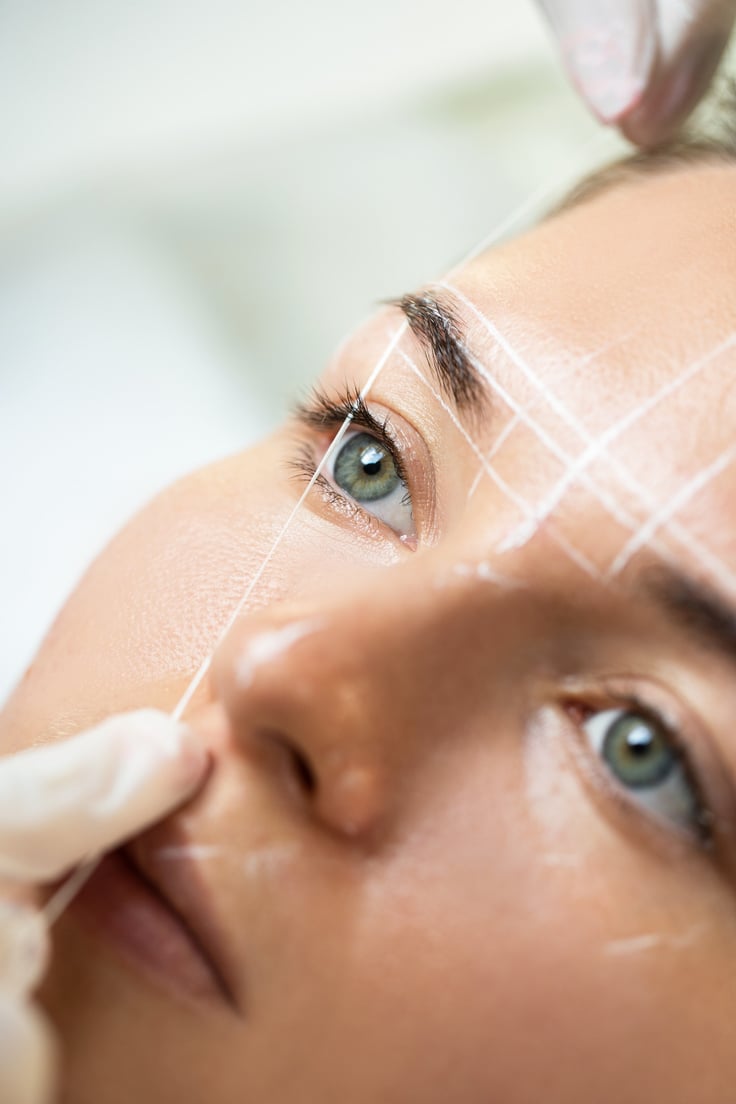 Woman during Professional Eyebrow Mapping Procedure